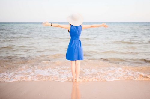 Young woman in blue dress at the beach
