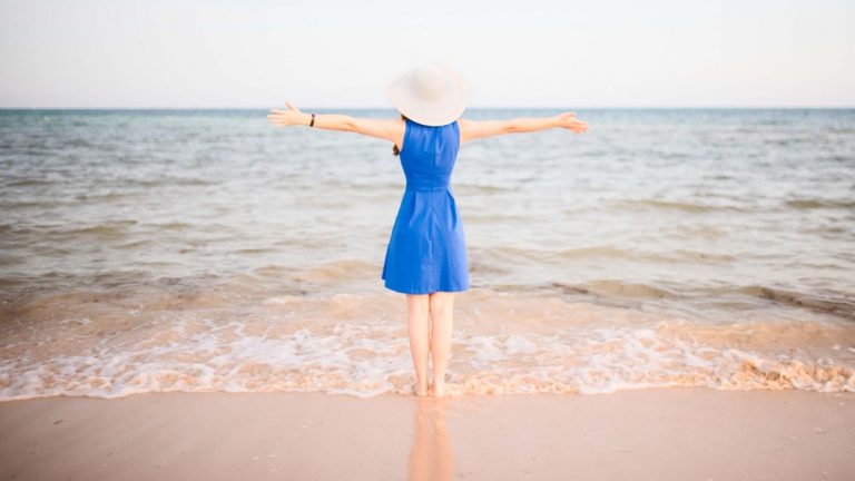 Young woman in blue dress at the beach
